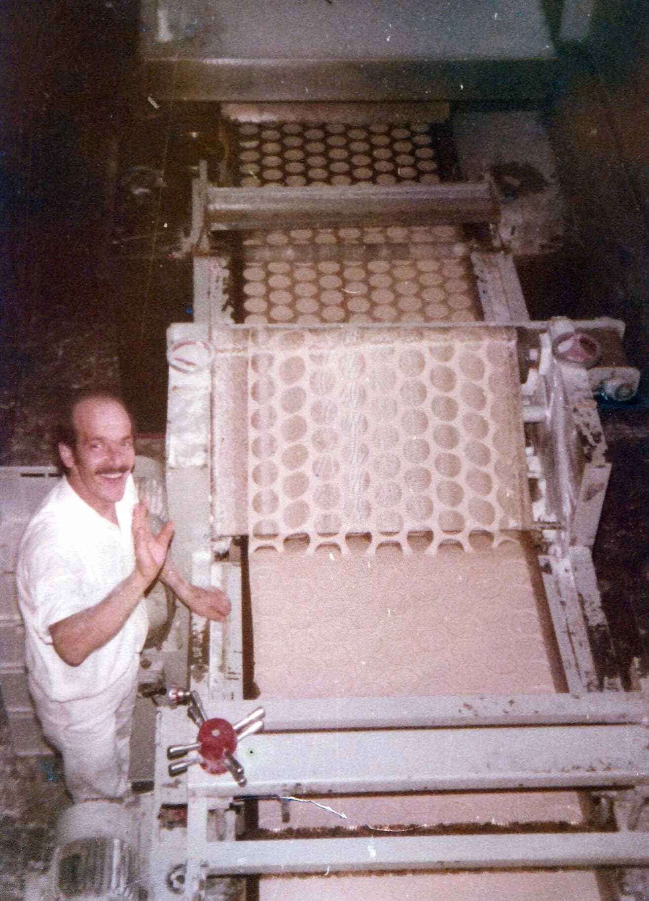 Carlos junto a una máquina de elaboración de galletitas Camet